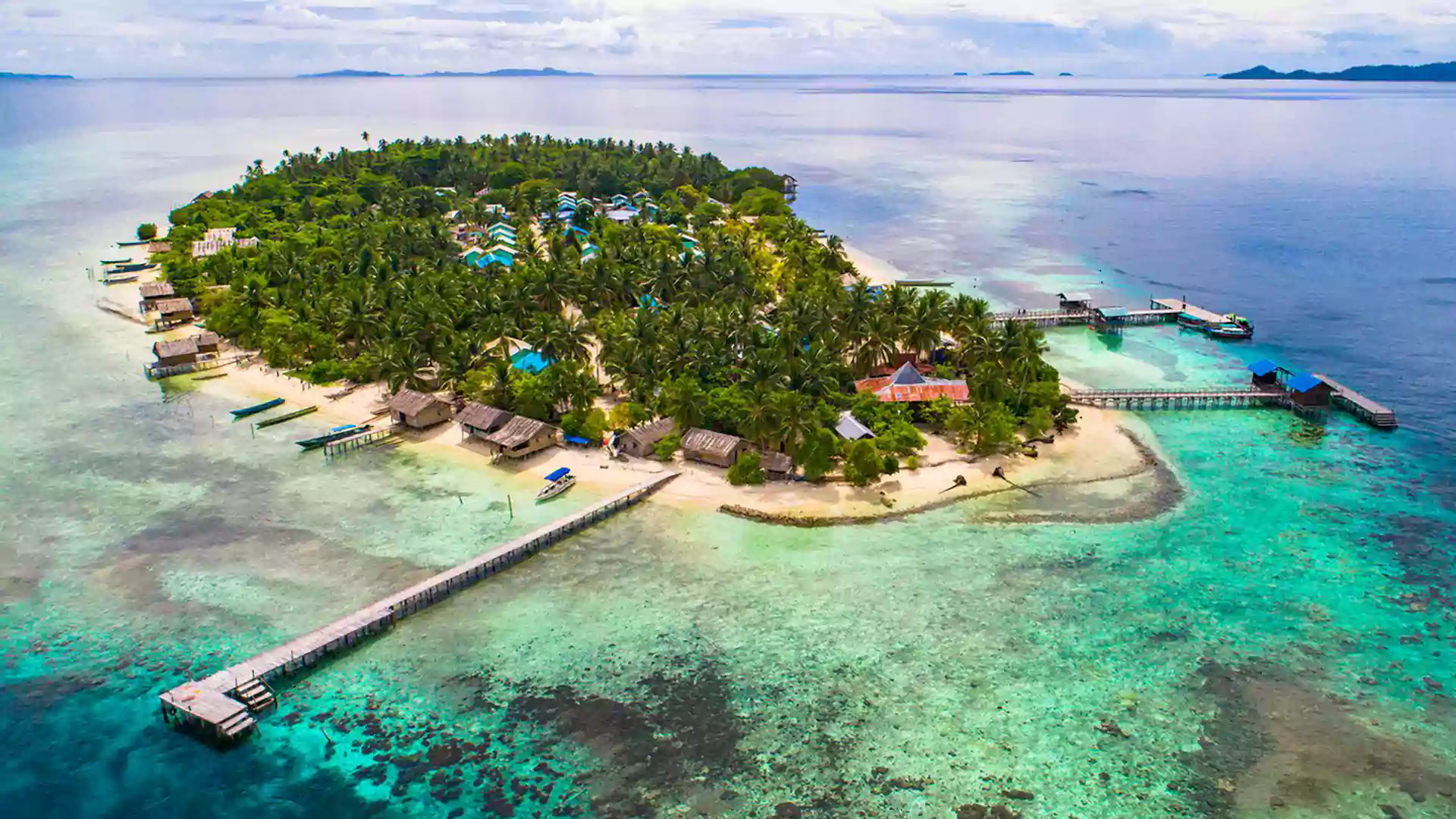 Pulau kecil di Raja Ampat dengan rumah penduduk di tepi pantai, cocok untuk wisata budaya Arborek.