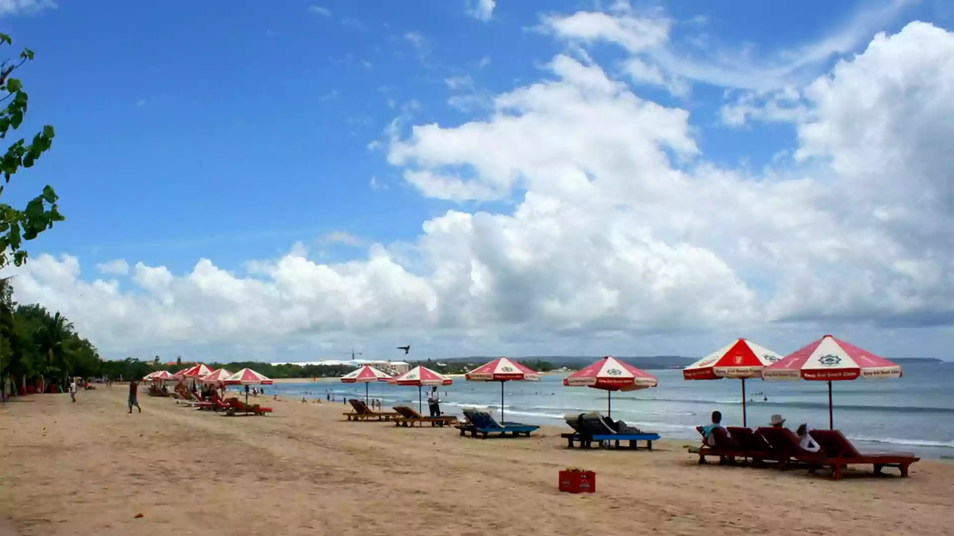 Suasana santai di Pantai Kuta Bali dengan pasir putih, payung pantai, cocok untuk <yoastmark class=