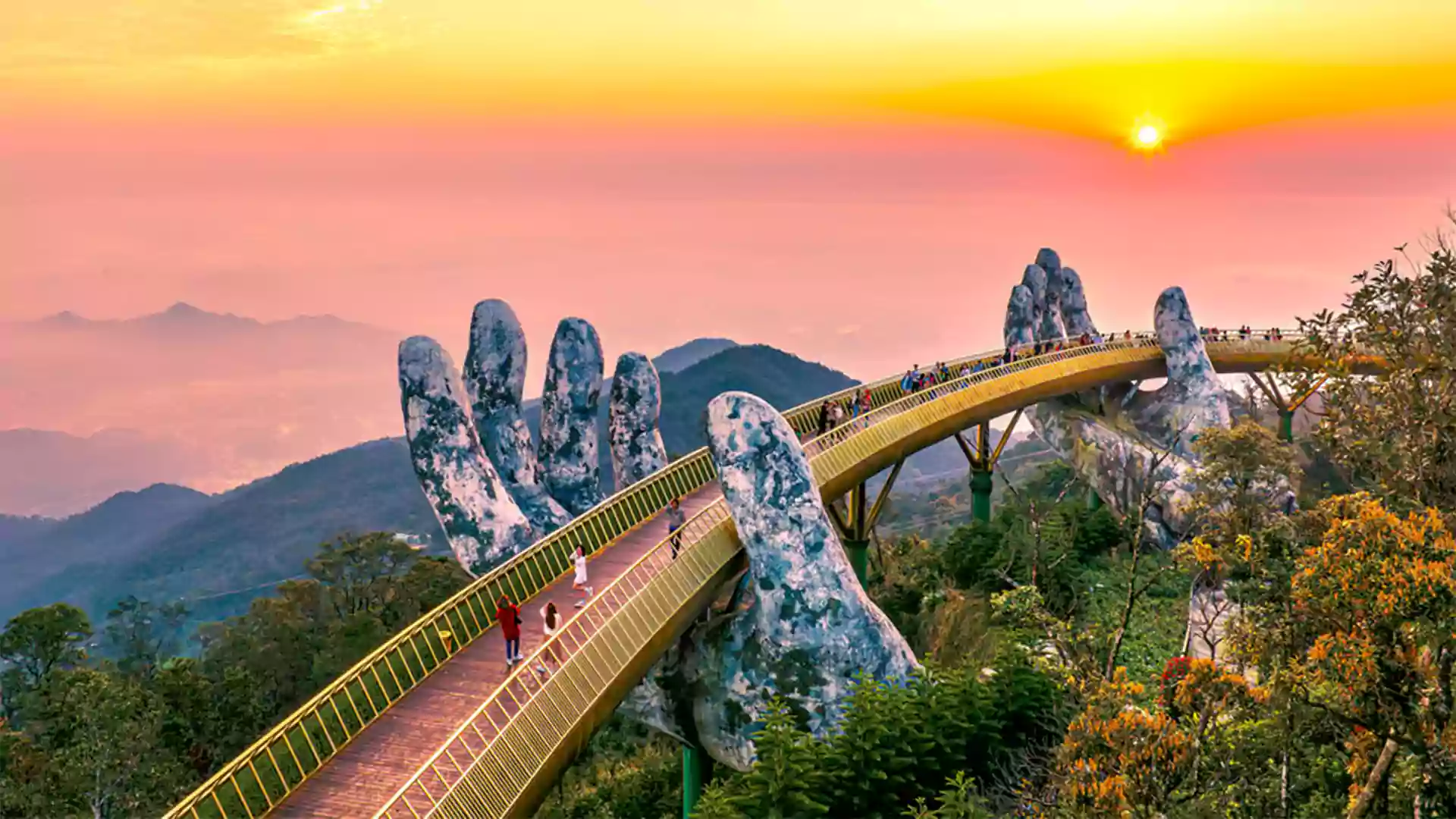 Golden Bridge di Da Nang dengan tangan raksasa yang menopang jembatan, dikelilingi pegunungan dan pemandangan matahari terbit