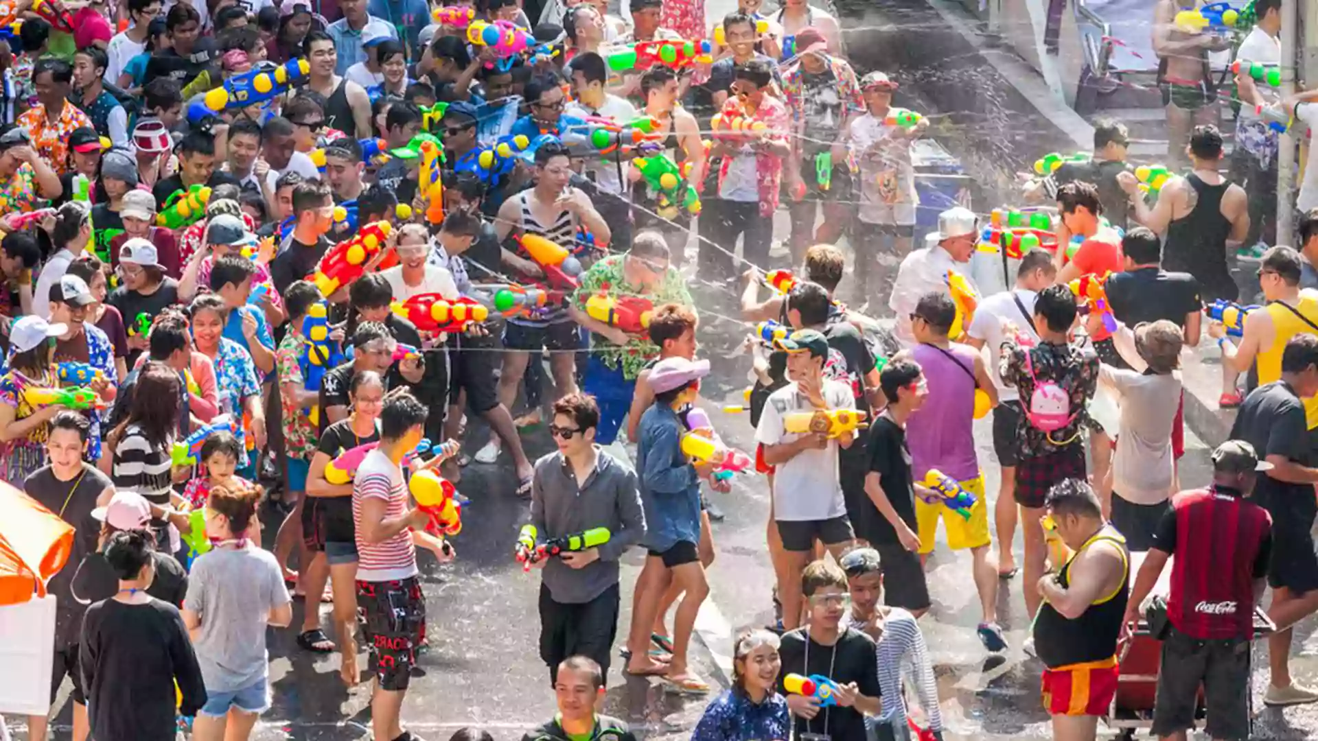 Keramaian Festival Songkran di Bangkok dengan wisatawan dan warga lokal saling menyiram air di jalan sebagai tradisi Tahun Baru Thailand.
