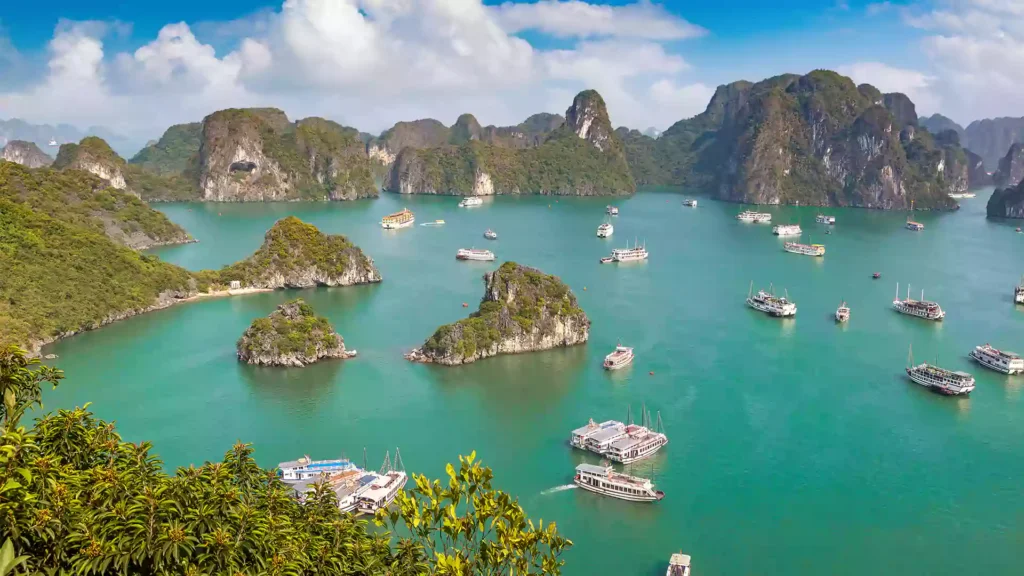 Pemandangan Teluk Halong Bay Vietnam dengan kapal wisata di air hijau toska, salah satu destinasi utama turis asing ke Vietnam 2026