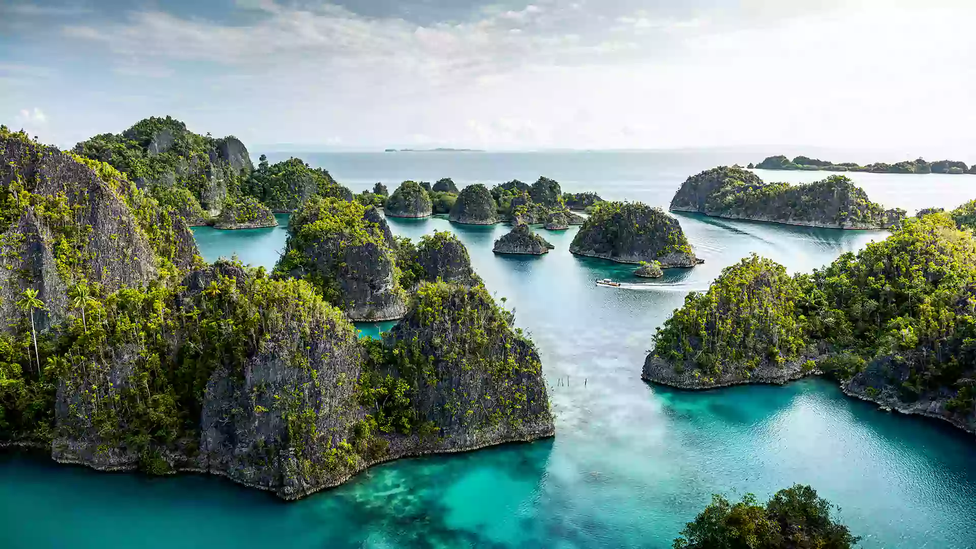 Kepulauan Raja Ampat dengan gugusan pulau karst hijau di atas laut biru jernih, salah satu destinasi terbaik Indonesia.